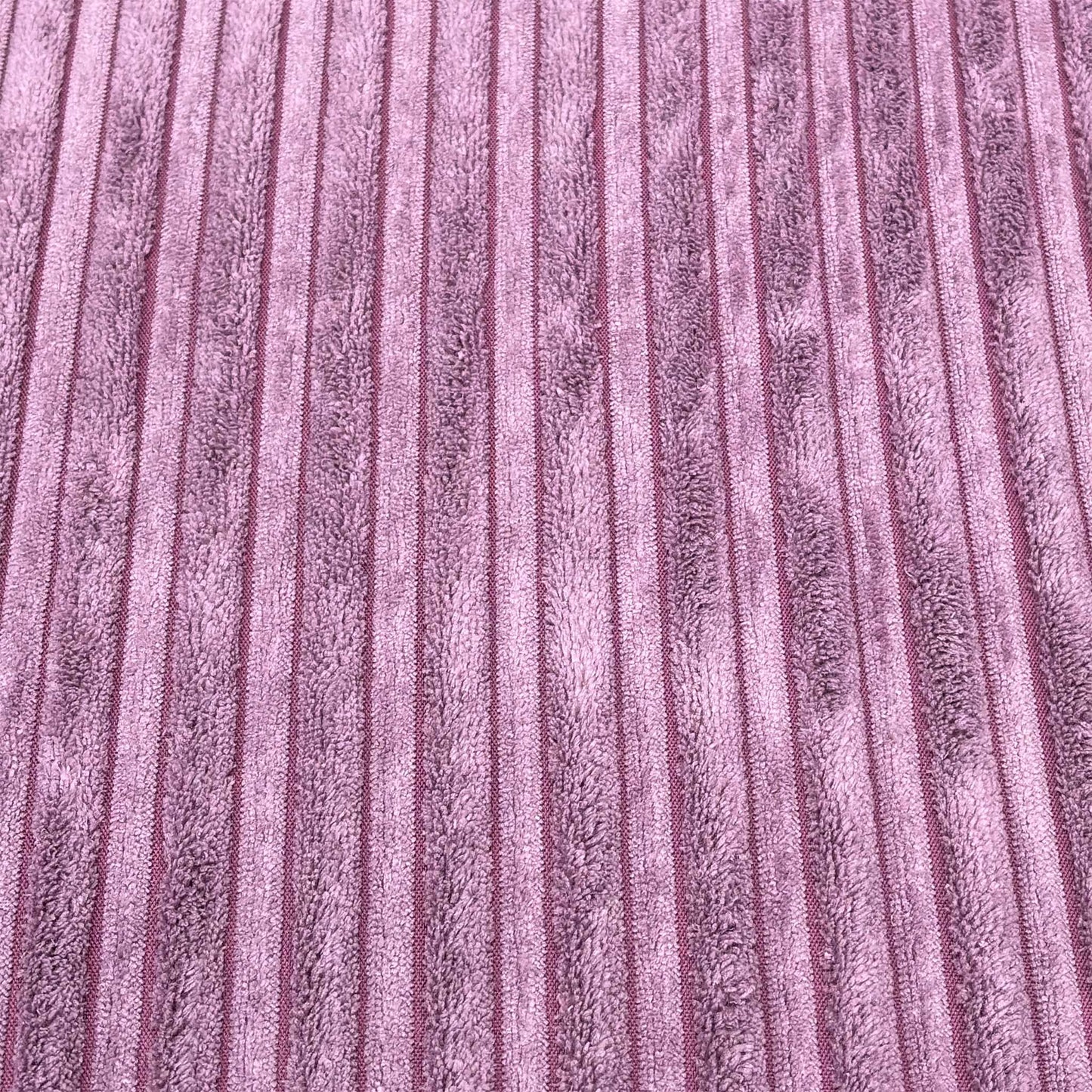 High-definition close-up macro view of the lilac purple Marley jumbo cord textile, displaying the thick, parallel ribbed lines and soft fabric pile.