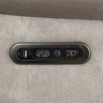 Detail shot of the integrated side control panel, showing the metallic buttons for power recline and headrest adjustment alongside a built-in USB charging port.