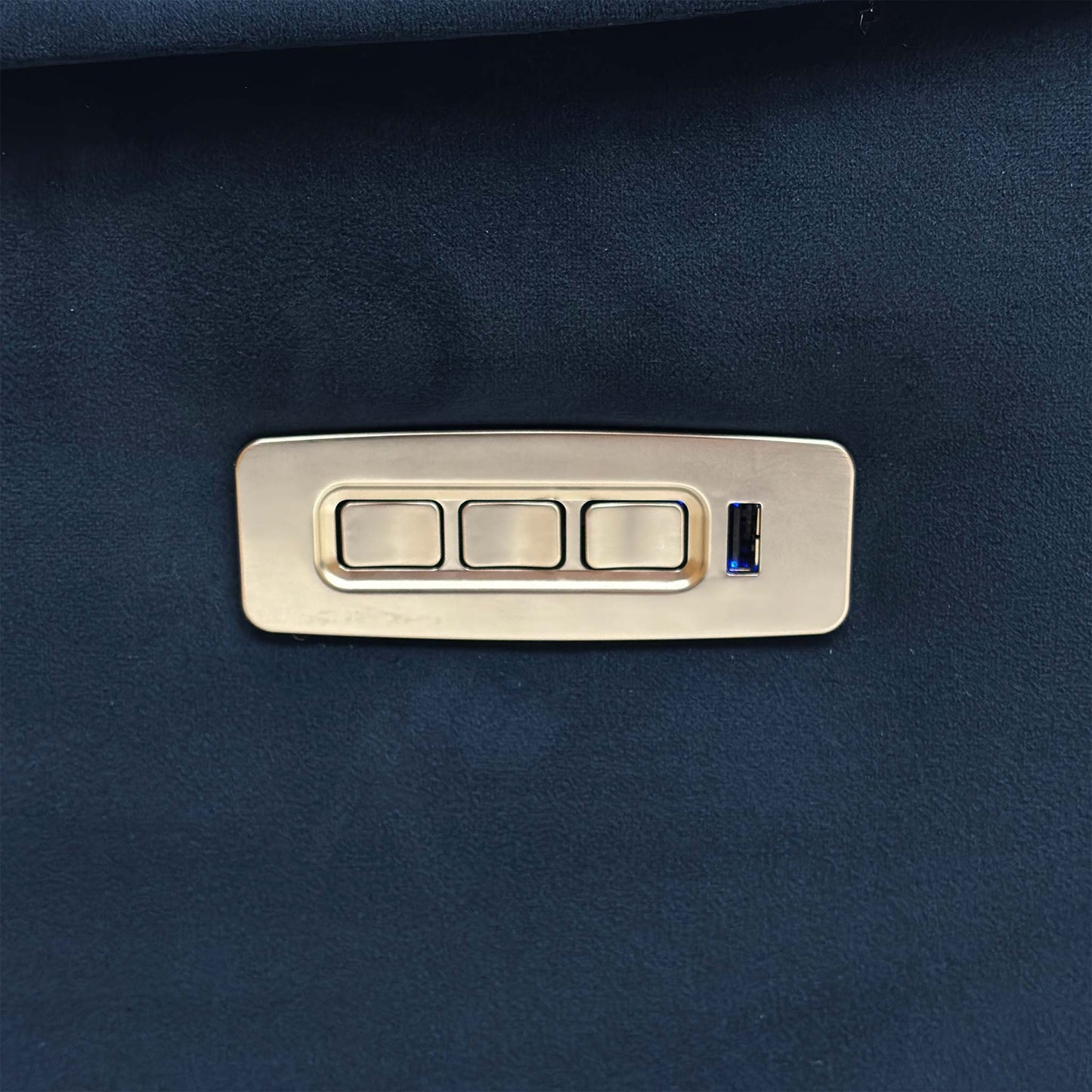 Close-up of the sleek side control panel, featuring metallic buttons for independent power recline, headrest, and lumbar adjustments, alongside a USB charging port.