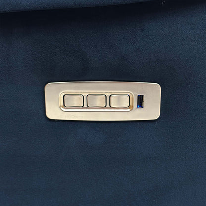 Close-up of the sleek side control panel, featuring metallic buttons for independent power recline, headrest, and lumbar adjustments, alongside a USB charging port.