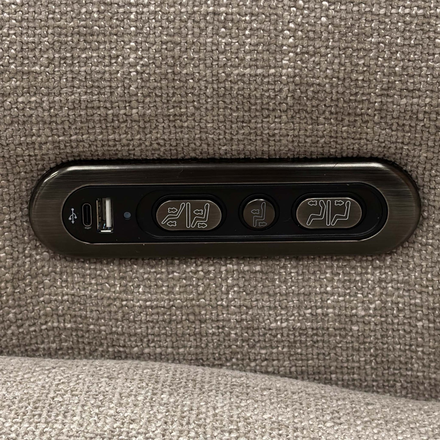 Detail shot of the sleek metallic control panel mounted on the side of the chair, including the buttons for power recline, headrest adjustments, and a built-in USB charging port.