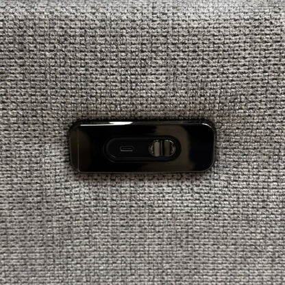 Detailed view of the sturdy circular swivel base mechanism and integrated USB device charging port on the side panel.