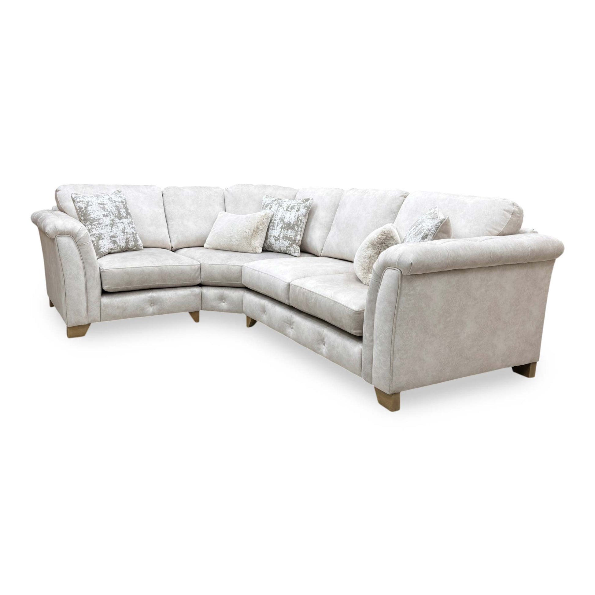 Side profile of the corner sofa, highlighting the beautifully sculpted rolled arms and premium velvet fabric finish.