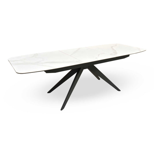 Full view of the Carrera 180cm extending dining table featuring a sleek white ceramic top with subtle marble veining and a sculptural black starburst metal base.