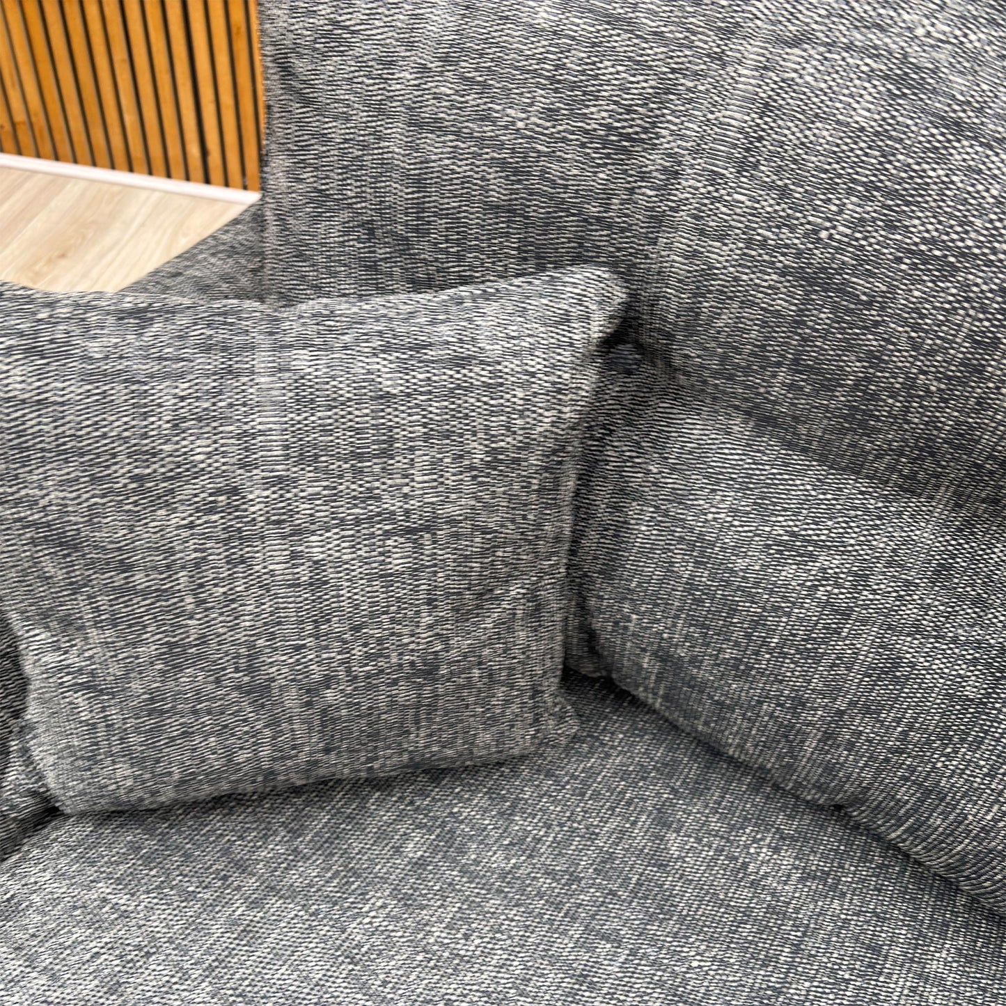 High-definition close-up shot of the charcoal fabric upholstery, highlighting its fine, durable weave pattern, rich dark grey tone, and high-quality tailored seams.