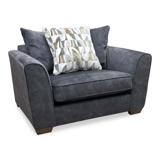 Full view of the Como snuggler chair, showcasing its wide 1.5-seater profile upholstered in a soft, premium coal-colored fabric with deep comfort cushioning.