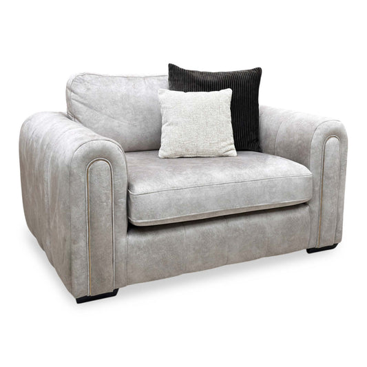 Full view of the Amara snuggle chair, upholstered in a premium stone grey fabric and featuring a wide, deeply cushioned seat and plush over-padded armrests.