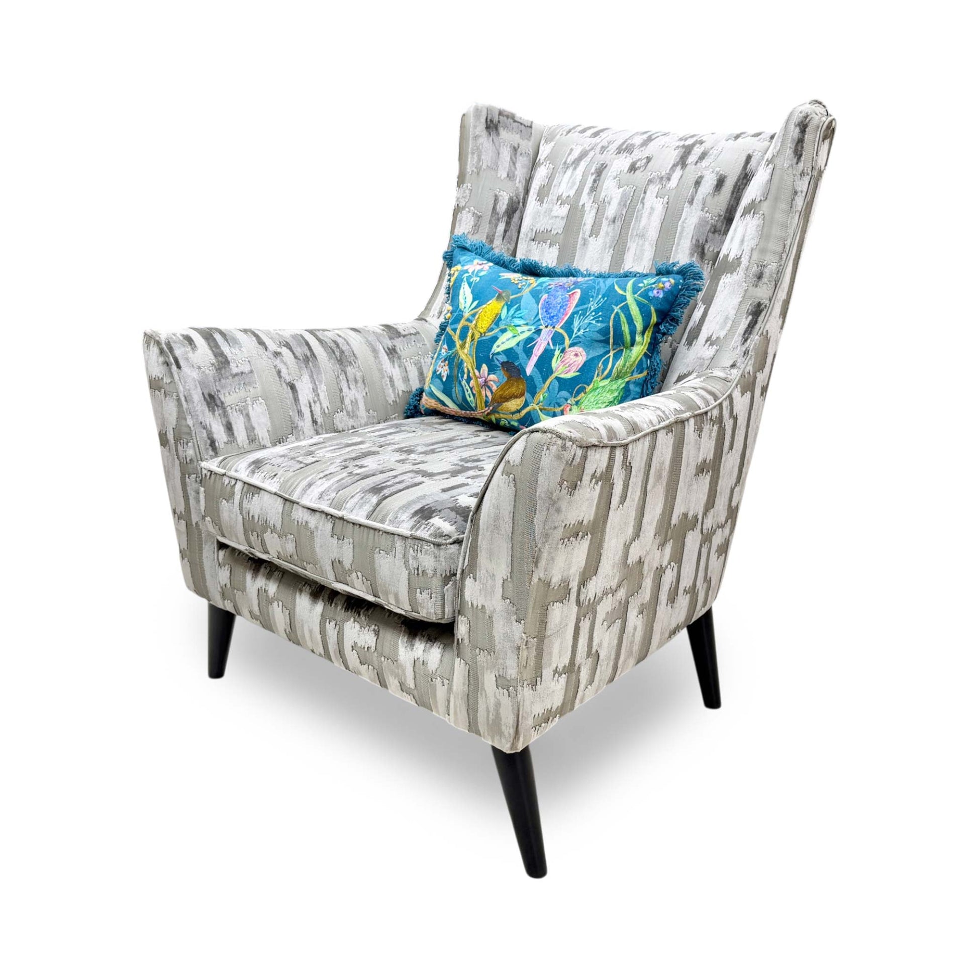 Side profile of the ‘Allure’ wing chair, highlighting its elegant, slender wings, sleek curved arm profile, and slim, tapered wooden legs.