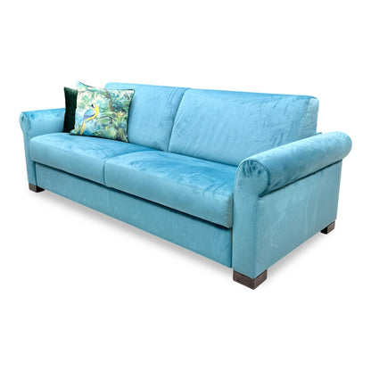 Side profile of the ‘Alcova’ velvet sofa, highlighting its sleek, low-profile arm design and sophisticated, understated proportions.