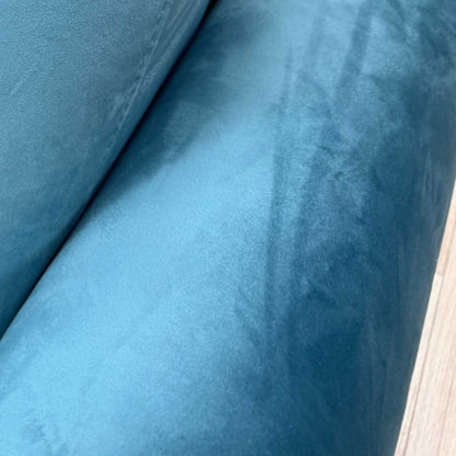 Close-up shot of the luxurious teal velvet fabric on the ‘Alcova’ sofa, showcasing the vibrant jewel tone and the rich, textured finish of the upholstery.