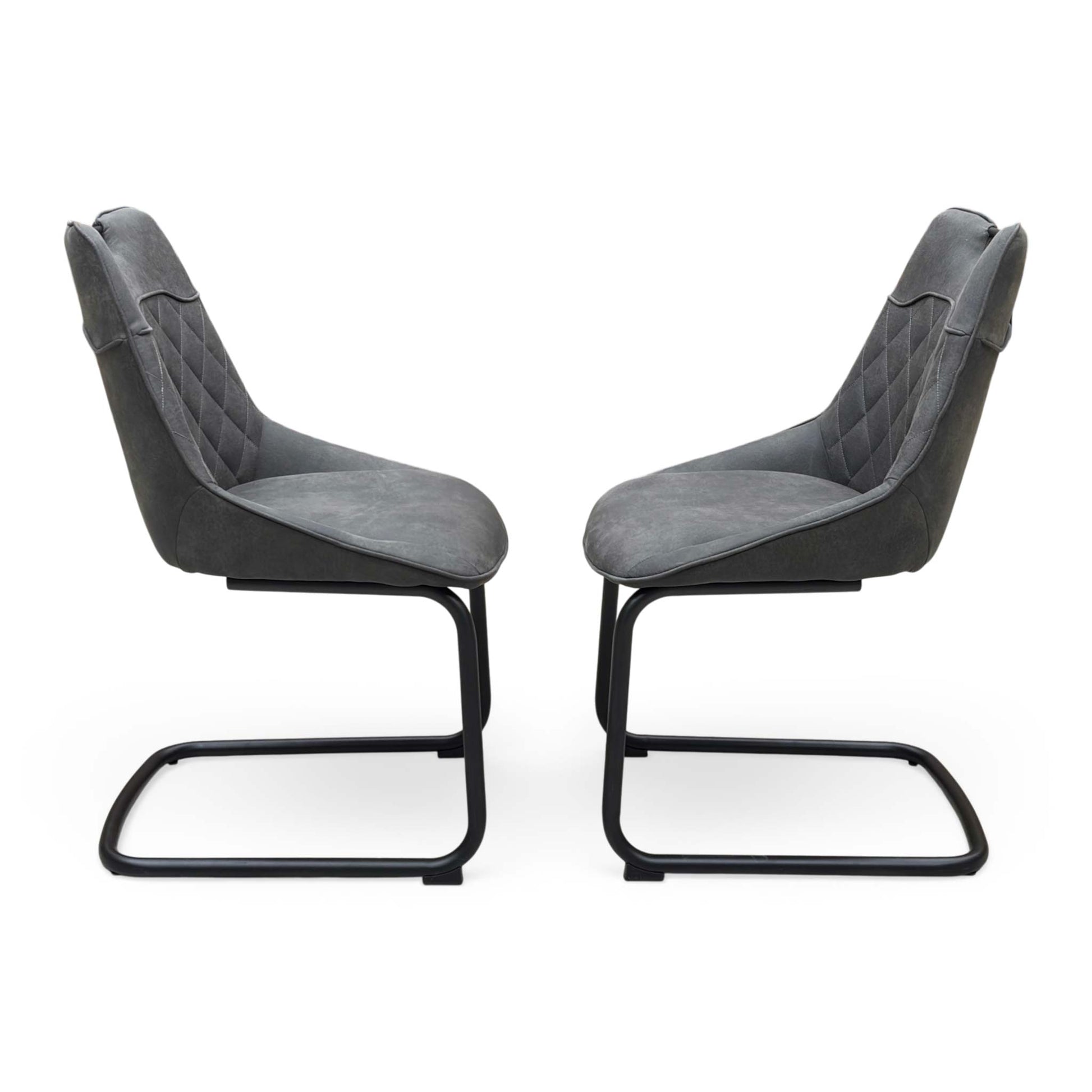 Front view of a pair of ‘Warrior’ Cantilever Dining Chairs in Charcoal Grey fabric, showcasing their sleek contemporary C-shaped frames, vertical channel-stitched backs, and minimalist industrial profile.
