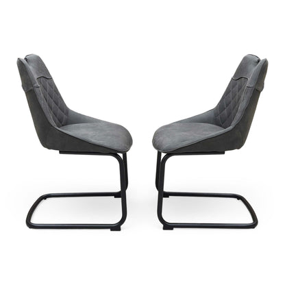 Front view of a pair of ‘Warrior’ Cantilever Dining Chairs in Charcoal Grey fabric, showcasing their sleek contemporary C-shaped frames, vertical channel-stitched backs, and minimalist industrial profile.