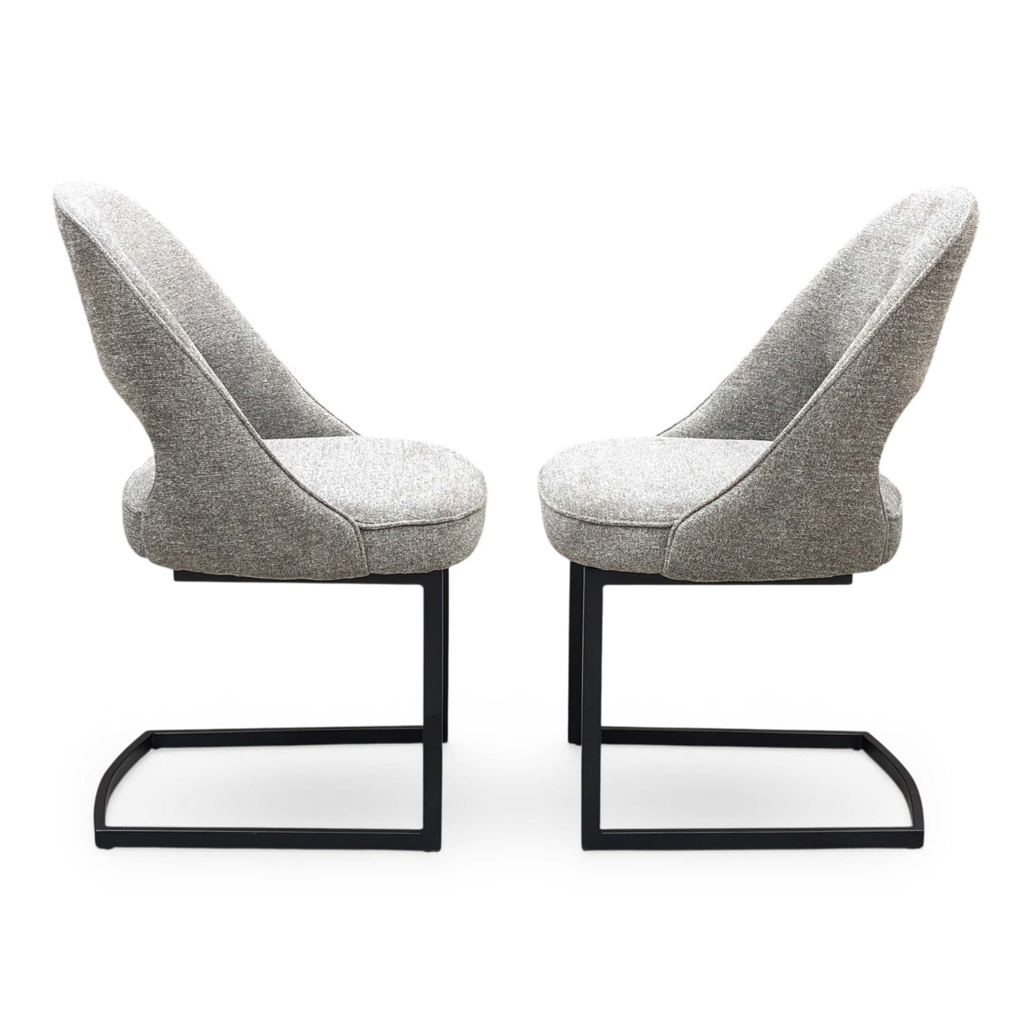 Front view of a pair of ‘Tiber’ Cantilever Dining Chairs in Truffle Brown fabric, showcasing their sleek contemporary C-shaped frames, vertical channel-stitched backs, and minimalist industrial profile.