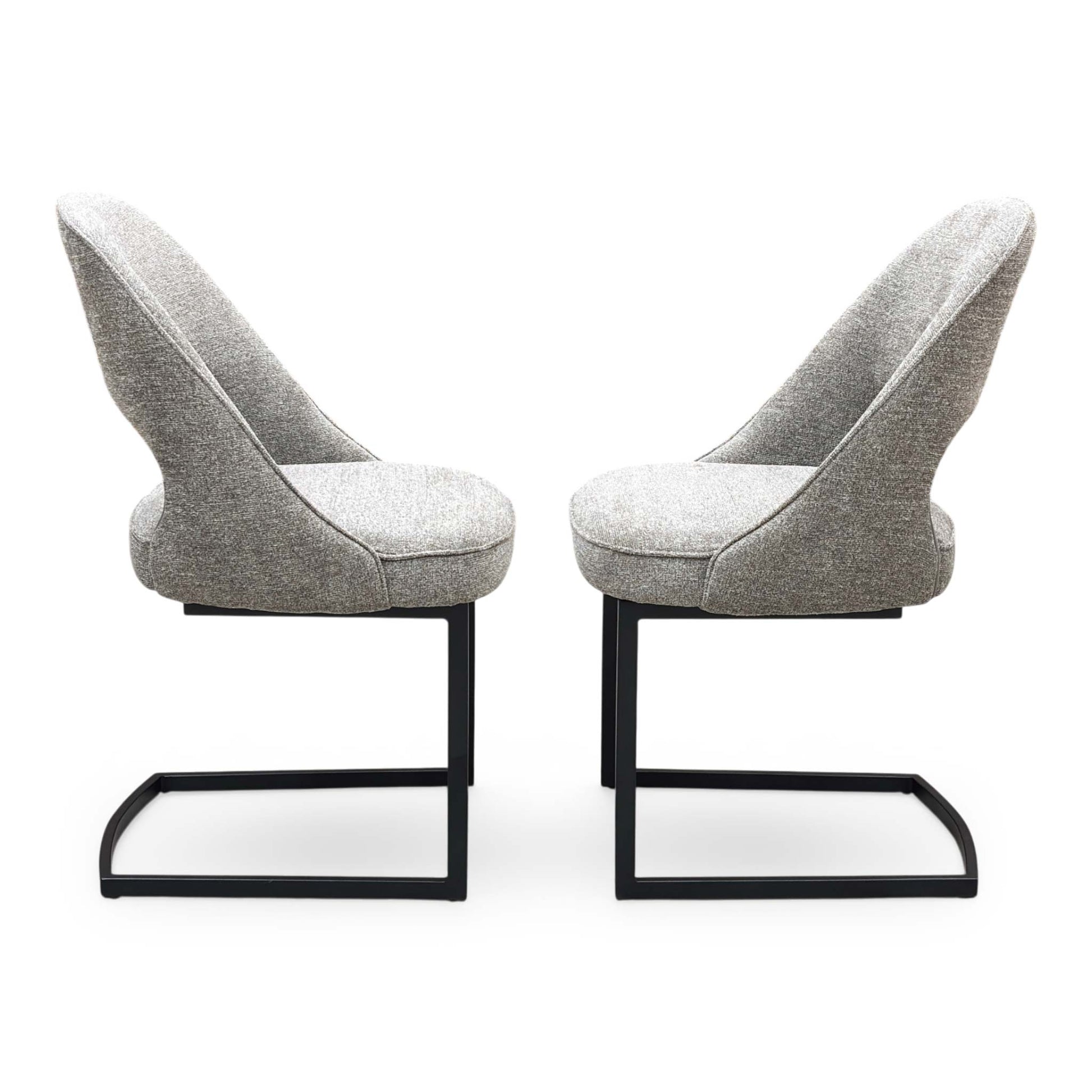 Front view of a pair of ‘Tiber’ Cantilever Dining Chairs in Truffle Brown fabric, showcasing their sleek contemporary C-shaped frames, vertical channel-stitched backs, and minimalist industrial profile.