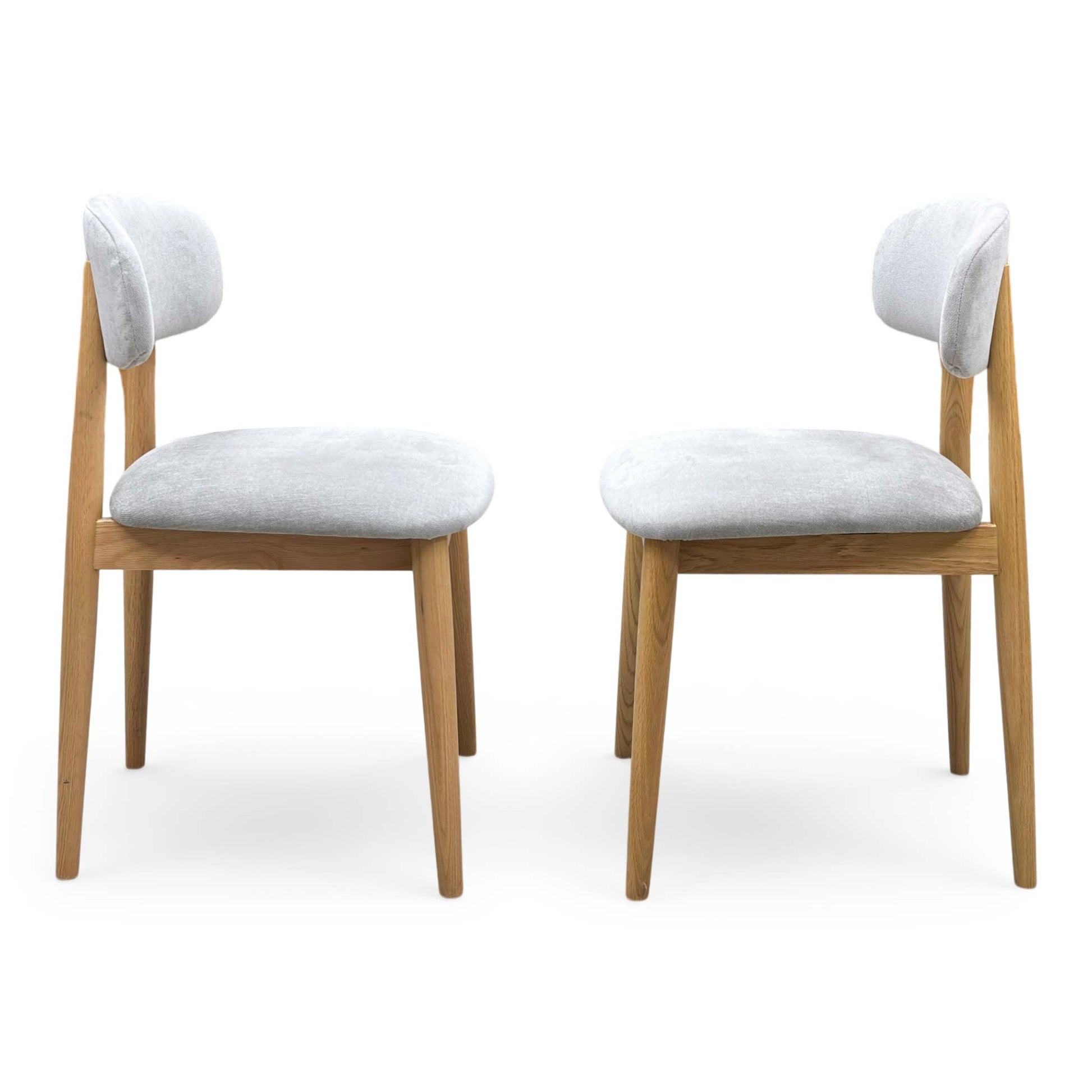 Front view of a pair of ‘Stockholm’ Dining Chairs in Light Oak, showcasing their clean Scandinavian design, minimalist slatted backrests, and smooth contoured wooden seats.
