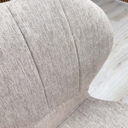 Macro detail of the Raul dining chair upholstery, showing the high-quality texture of the pebble taupe fabric and the precise vertical channel-stitched backrest panel.