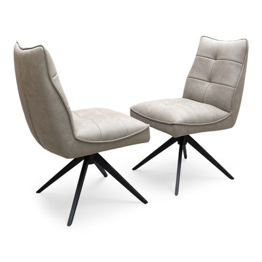 Full view of a pair of ‘Germain’ Swivel Dining Chairs in Taupe faux leather, showcasing their sleek contemporary scoop silhouettes, vertical channel stitching, and elegant black metal legs.