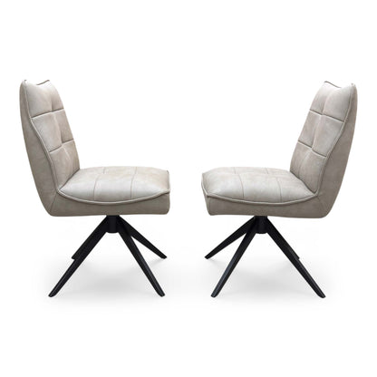 Front view of a pair of ‘Germain’ Swivel Dining Chairs in Taupe faux leather, showcasing their sleek contemporary scoop silhouettes, vertical channel stitching, and elegant black metal legs.