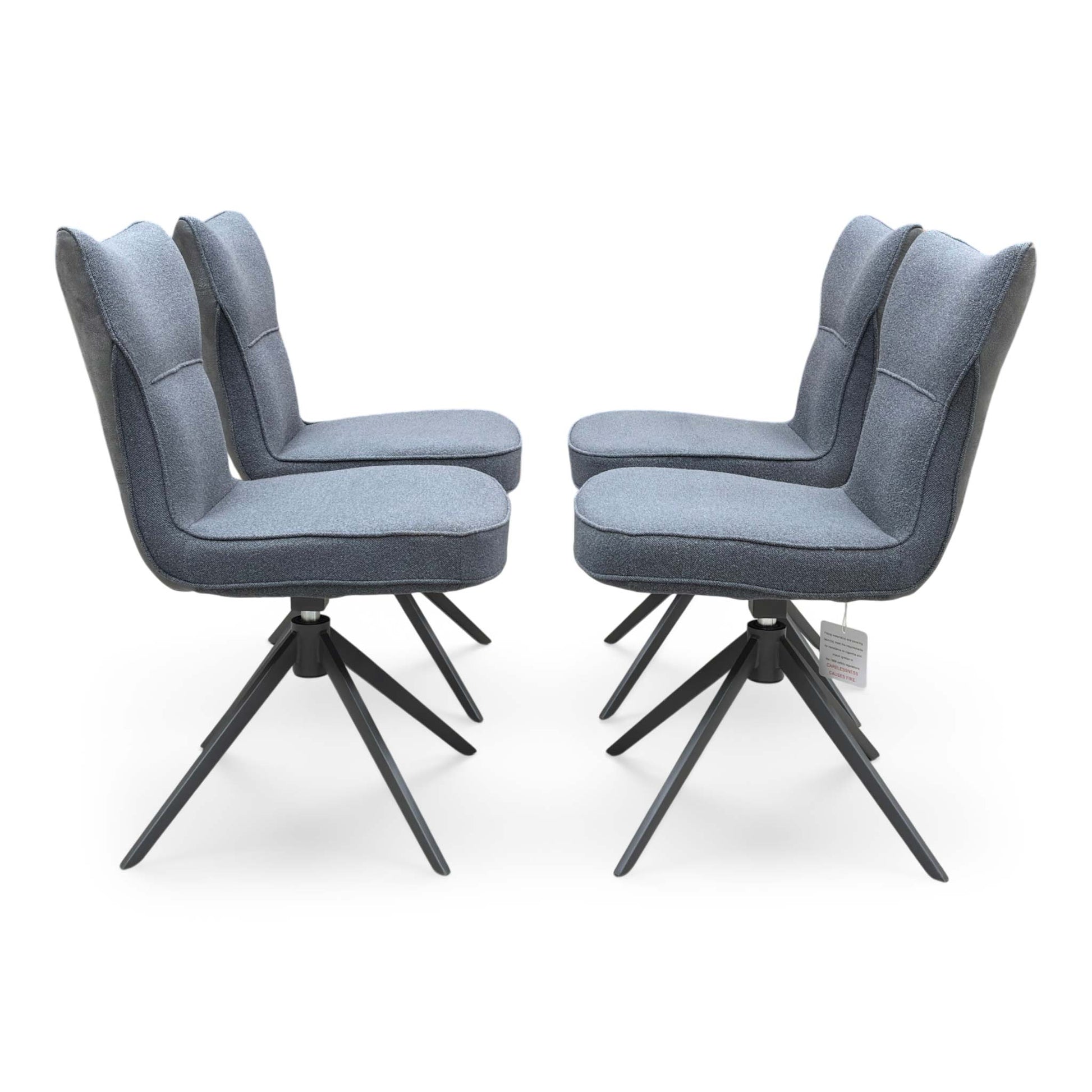 Front view of a set of 4 ‘Carrera’ Swivel Dining Chairs in Grey fabric, showcasing their contemporary diamond-stitched bucket seats, supportive wrap-around silhouettes, and sleek black metal spider legs.