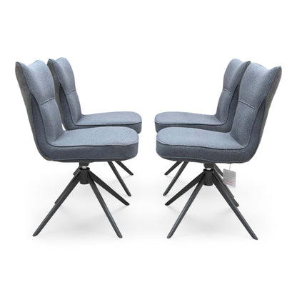 Front view of a set of 4 ‘Carrera’ Swivel Dining Chairs in Grey fabric, showcasing their contemporary diamond-stitched bucket seats, supportive wrap-around silhouettes, and sleek black metal spider legs.