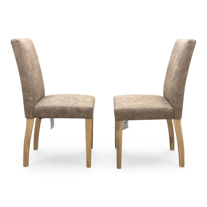Front view of the ‘Augusta’ dining chair, emphasizing the comfortable deeply padded seat cushion and the elegant contrast between the warm taupe upholstery and dark legs.