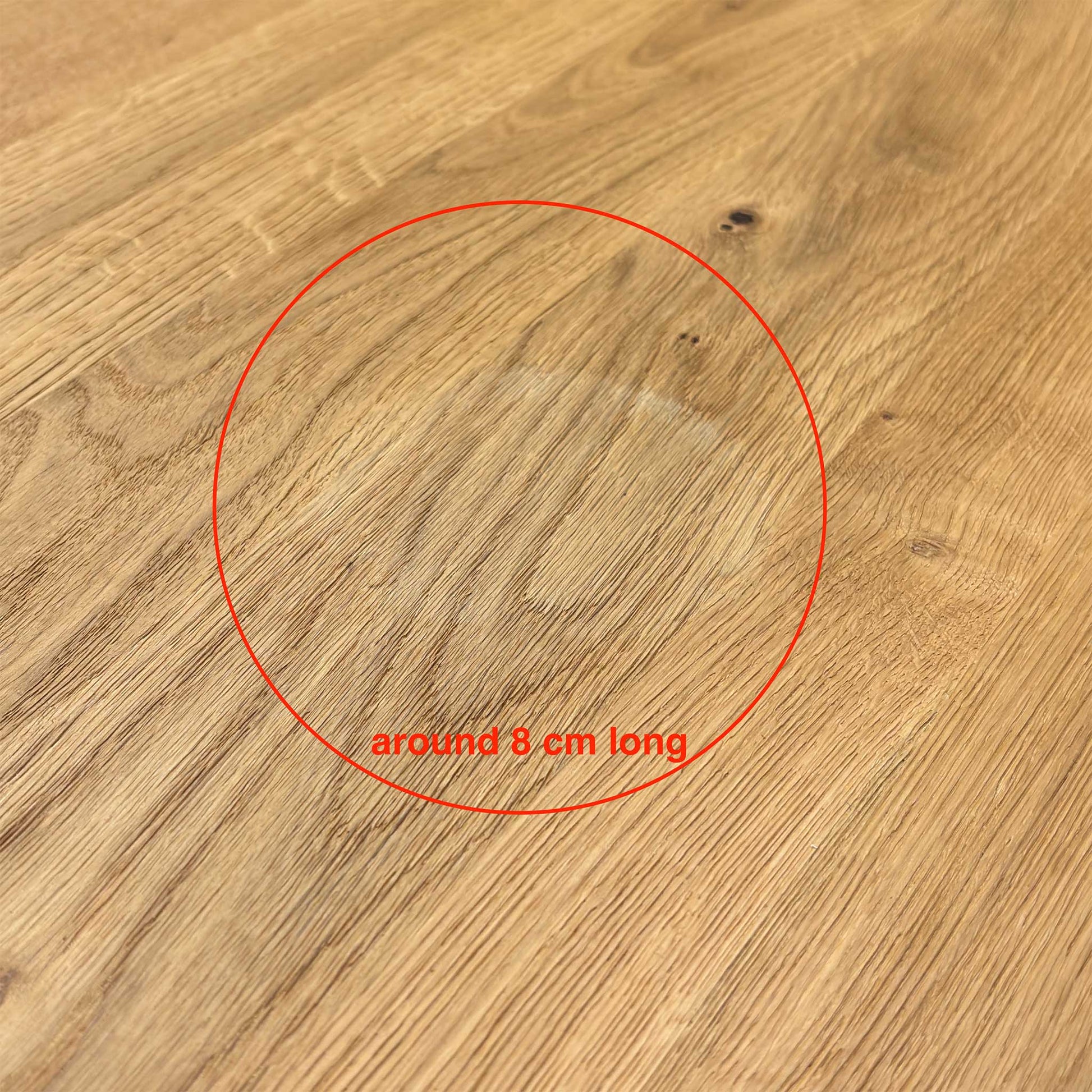Close-up shot of the solid natural oak table top on the ‘Earth’ dining table, showcasing the rich wire-brushed texture, distinctive natural character markings, and oiled finish.