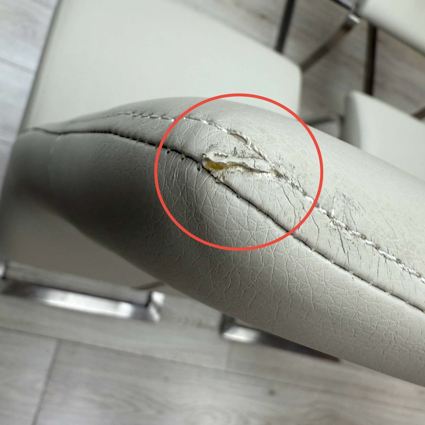 Close-up macro detail of the taupe faux leather upholstery, highlighting the realistic leather-grain texture, durable finish, and warm neutral color tone.