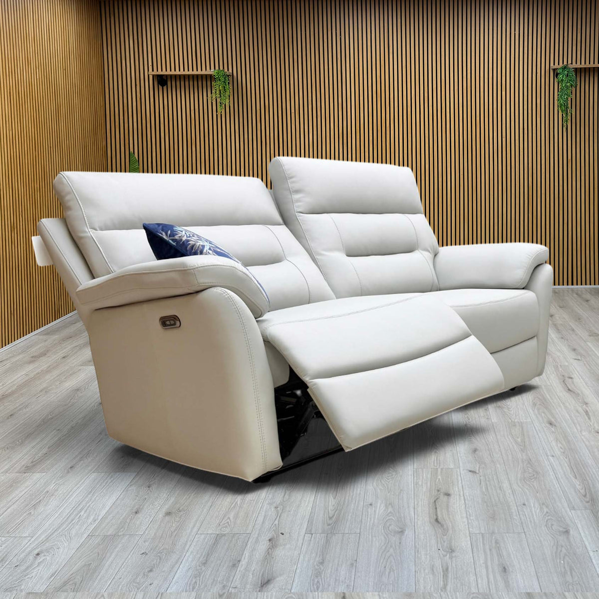 The Sally light grey leather 3 seater sofa from the set with one seat reclined, against a slatted wooden wall