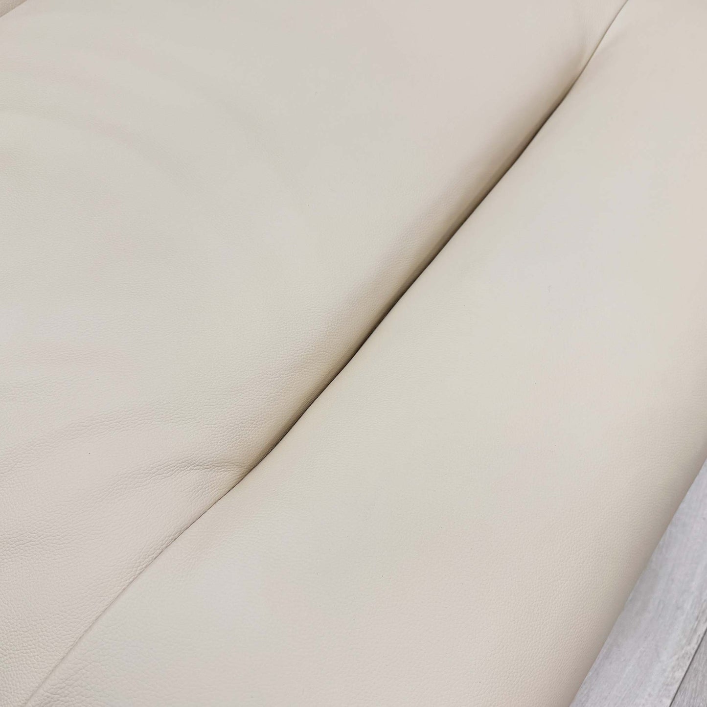 High-definition close-up macro view of the premium Taupe leather upholstery, detailing the authentic natural grain texture, soft-touch finish, and rich neutral tone.