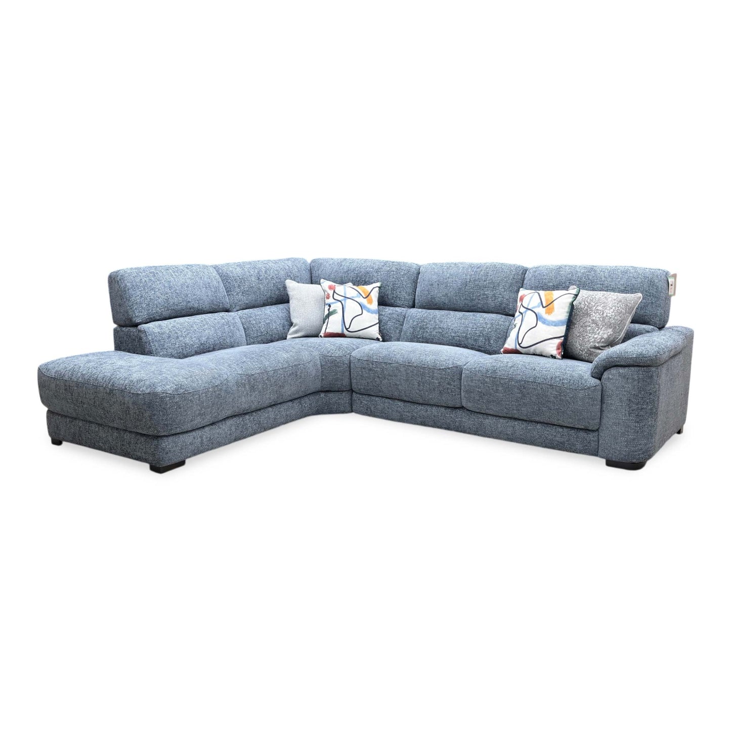Front view of the Nova corner chaise end sofa in silverish blue fabric, showcasing its spacious L-shaped layout, contemporary block-cushion design, and plush scatter cushions.