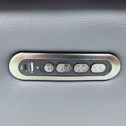 Detailed view of the integrated sleek metallic power control panel on the outer arm side, featuring buttons for reclining, headrest, and lumbar adjustment.