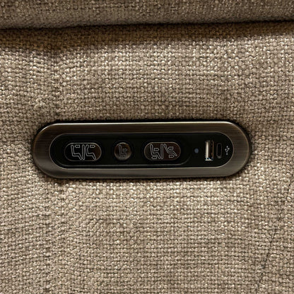 Detailed view of the sleek metallic outer armrest control switch panel, featuring integrated buttons for independent power recline and headrest adjustments.