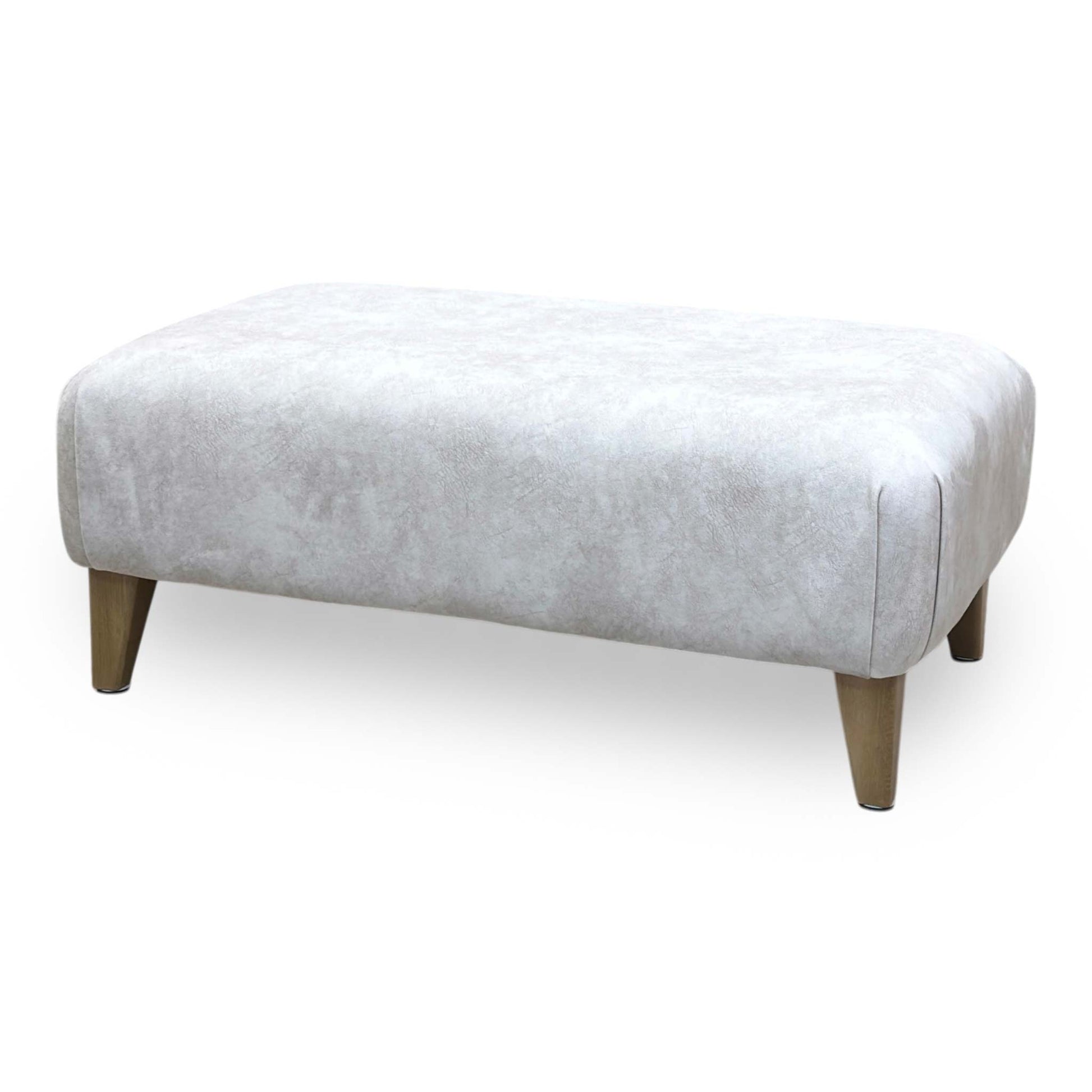 Side profile view demonstrating the footstool's compact height, balanced linear proportions, and tightly upholstered base paneling.