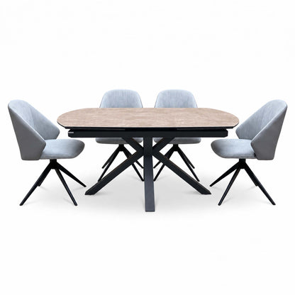 Front view of the Raul argile ceramic dining table with 4 grey swivel chairs, two at each end