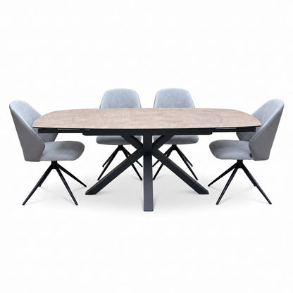 Raul argile ceramic dining table and 4 grey swivel chairs from a lower front angle, black cross base