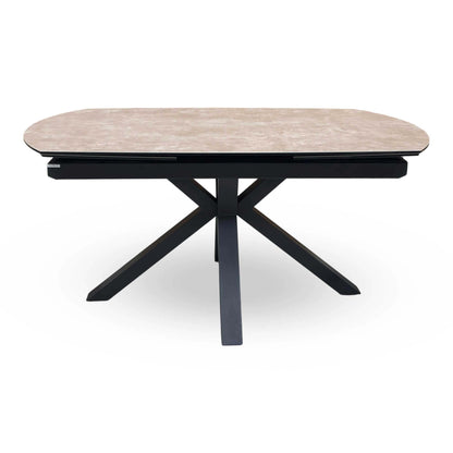 Front view of the Raul argile ceramic top dining table with rounded ends and black cross legs