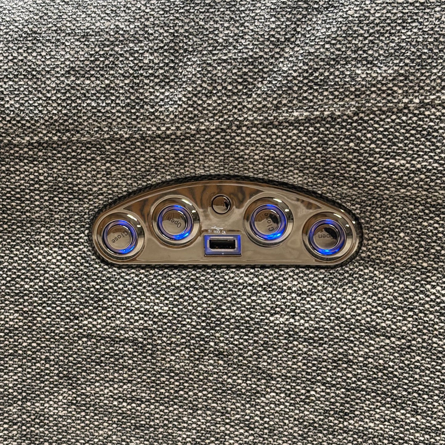 Macro view of the Link SKA-R31 charcoal grey fabric, emphasizing the high-quality woven textile texture, tight seams, and side control panel with an integrated USB charging port.