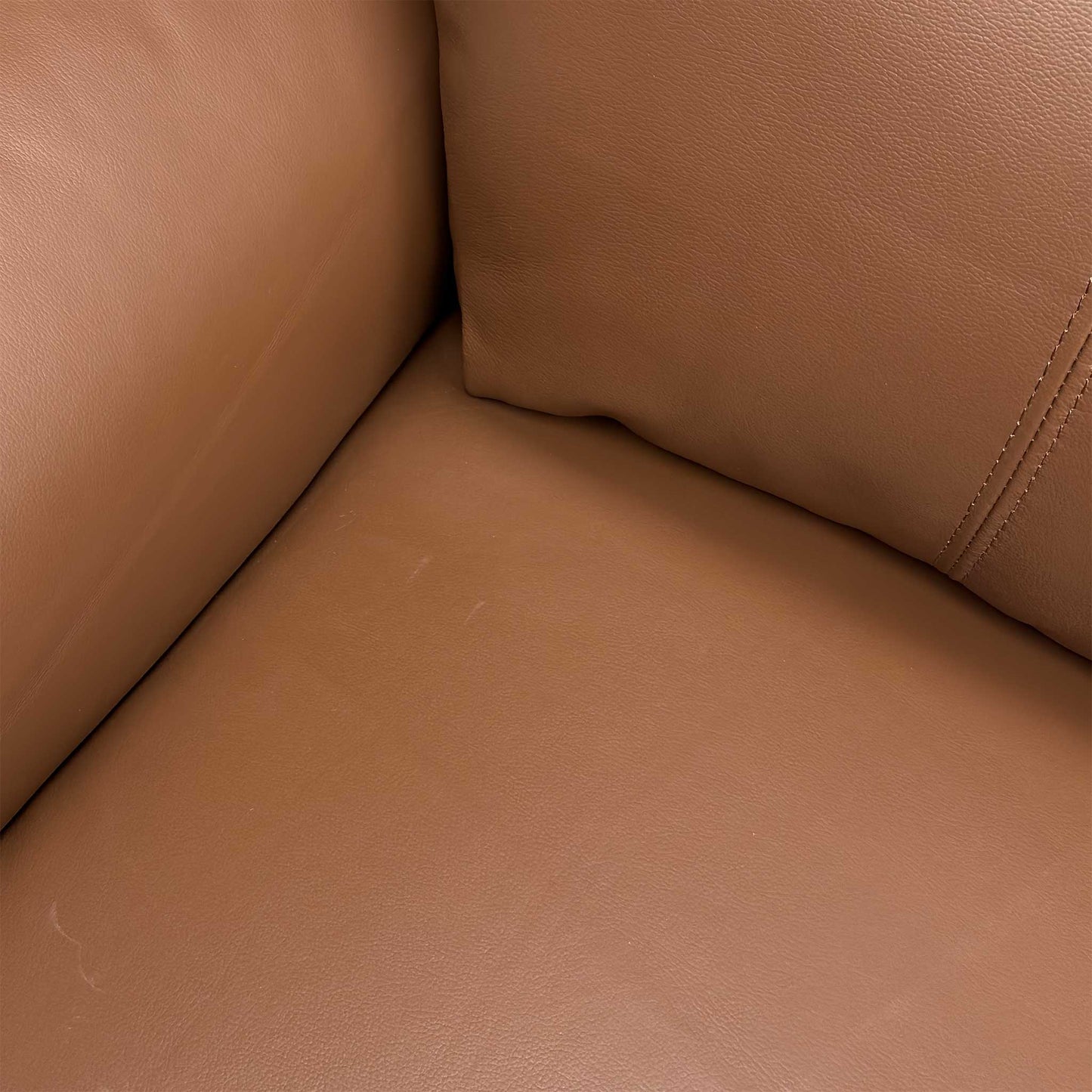 Close up view of the Bobby 3-seater sofa, displaying the fully upholstered tan brown leather back panels and neat power cable layout for flexible placement.