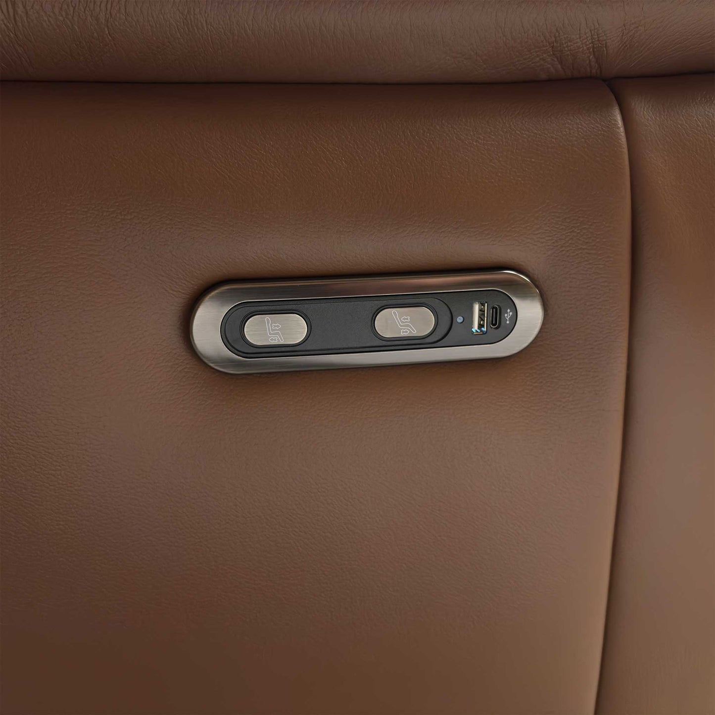 Close-up of the integrated metallic control panel on the side of the Bobby sofa, showing the smooth power reclining buttons and built-in USB charging port.