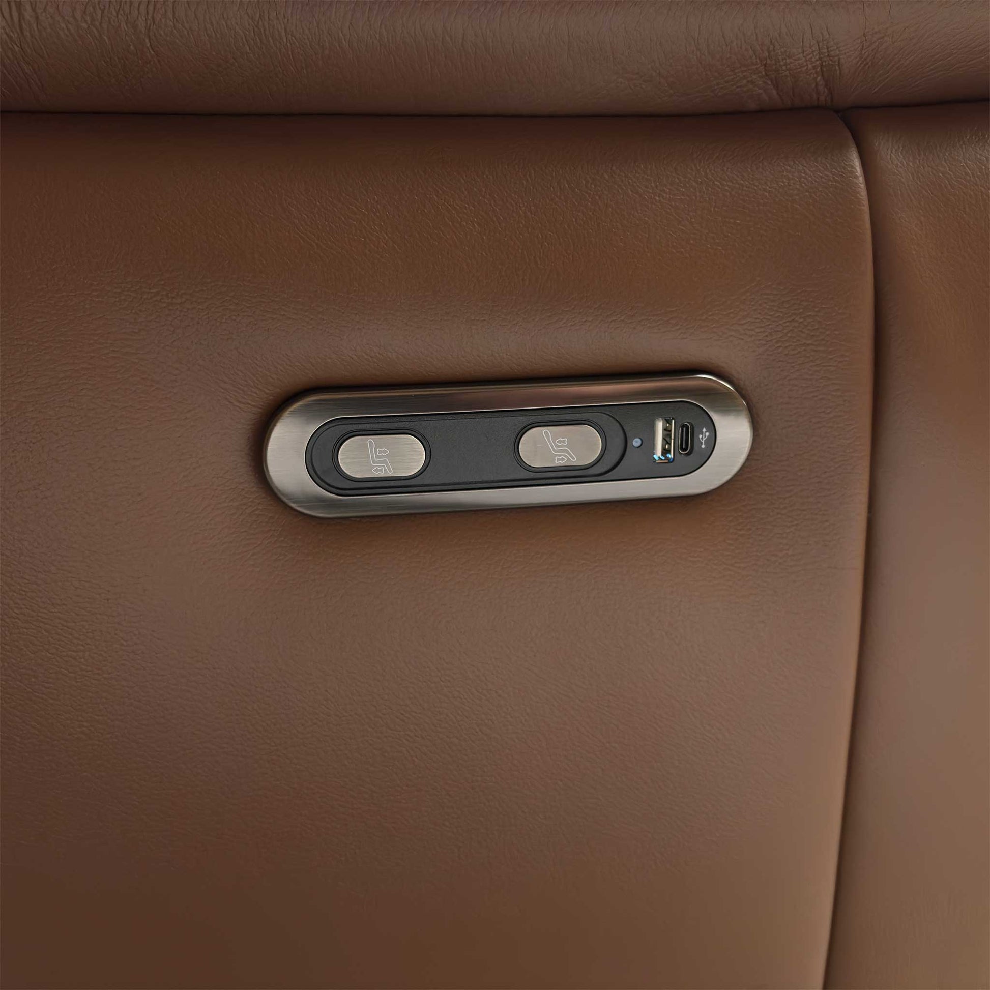 Close-up of the integrated metallic control panel on the side of the Bobby sofa, showing the smooth power reclining buttons and built-in USB charging port.