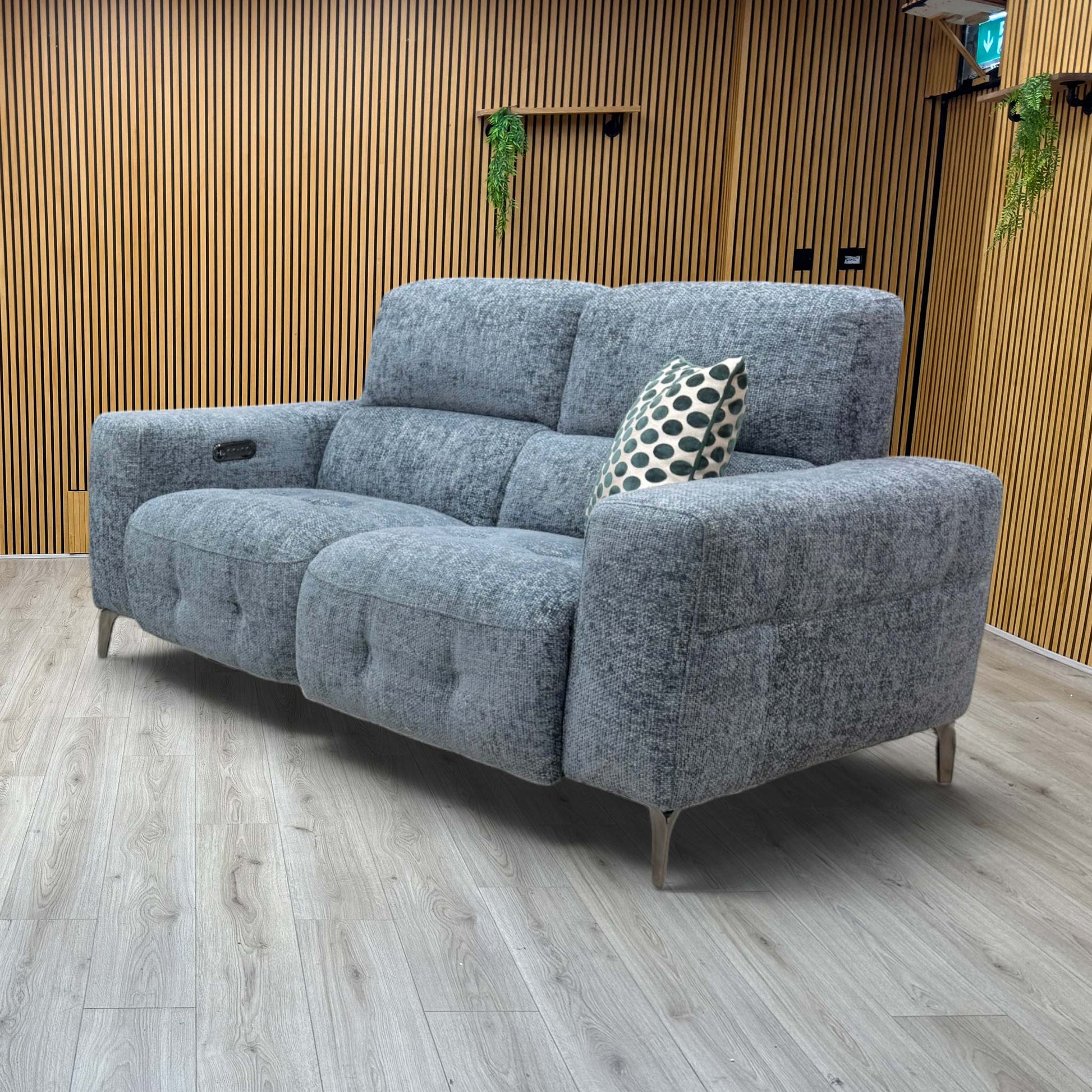 Lifestyle view of  three-quarter angled view of the New York silverish blue power reclining fabric couch, highlighting its contemporary tailored design and vibrant mid-tone finish.