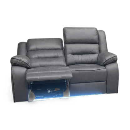 Side view of vegas charcoal grey home cinema power reclining sofa shown in a darkened room. Highlights the vibrant ambient blue LED under-glow light strip running along the base, creating an authentic movie theater atmosphere at home.