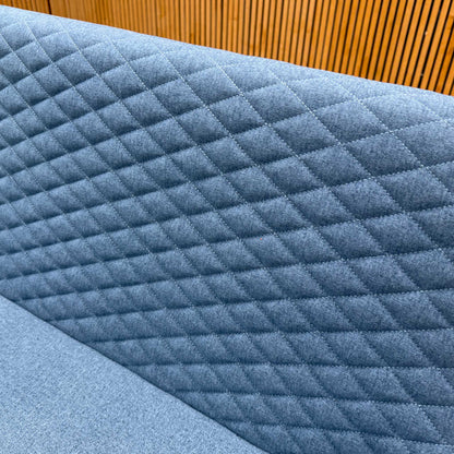 Close-up of the diamond quilting on the mineral blue fabric back of the Rocket dining bench