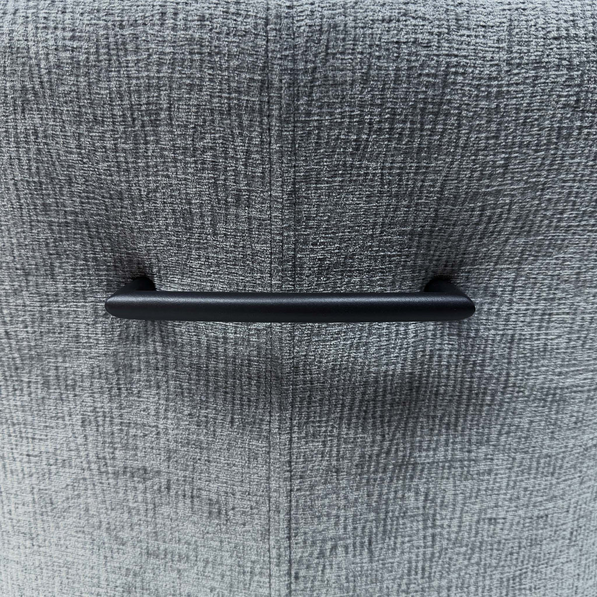 Close-up of the black metal grab handle on the back of a Crete dark grey fabric swivel dining chair