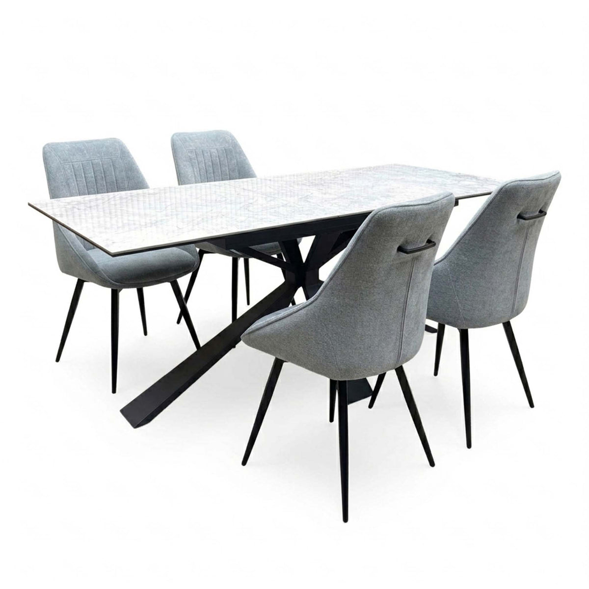 Crete ceramic top dining table with four dark grey fabric swivel chairs, angled from the right