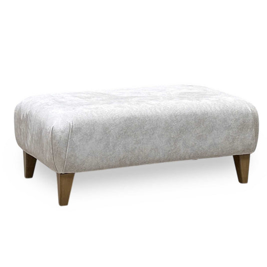 Aura Kenzo Cream fabric footstool front view. Contemporary upholstered square ottoman featuring plush textured cream fabric, clean tailored edges, and a low-profile minimalist silhouette designed to complement modern living spaces.