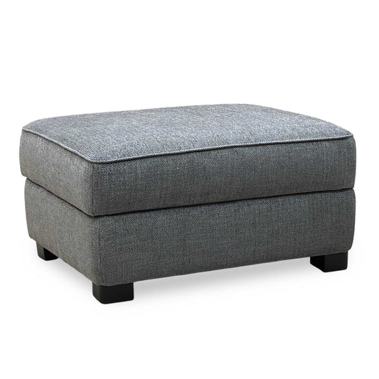 Gray upholstered ottoman on a white background