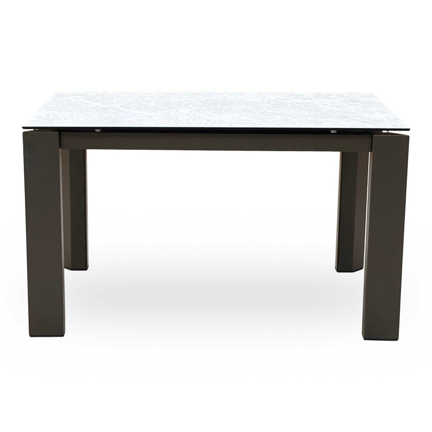 Front-facing view of the Connubia Viola dining table in its standard unextended position, highlighting the seamless clean lines, elegant corner-positioned legs, and architectural silhouette.