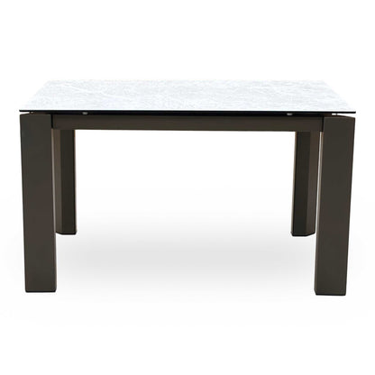 Front-facing view of the Connubia Viola dining table in its standard unextended position, highlighting the seamless clean lines, elegant corner-positioned legs, and architectural silhouette.