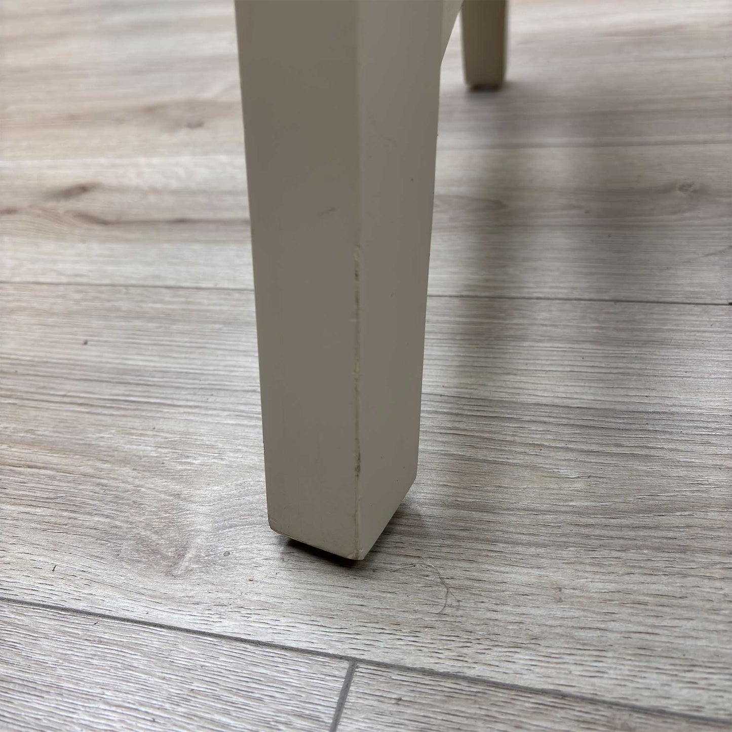 Close-up view from a high angle looking down at the seat and backrest junction, displaying the flawless edge finishing, tight tolerances, and pristine tailored construction lines.Damage on chair Legs.